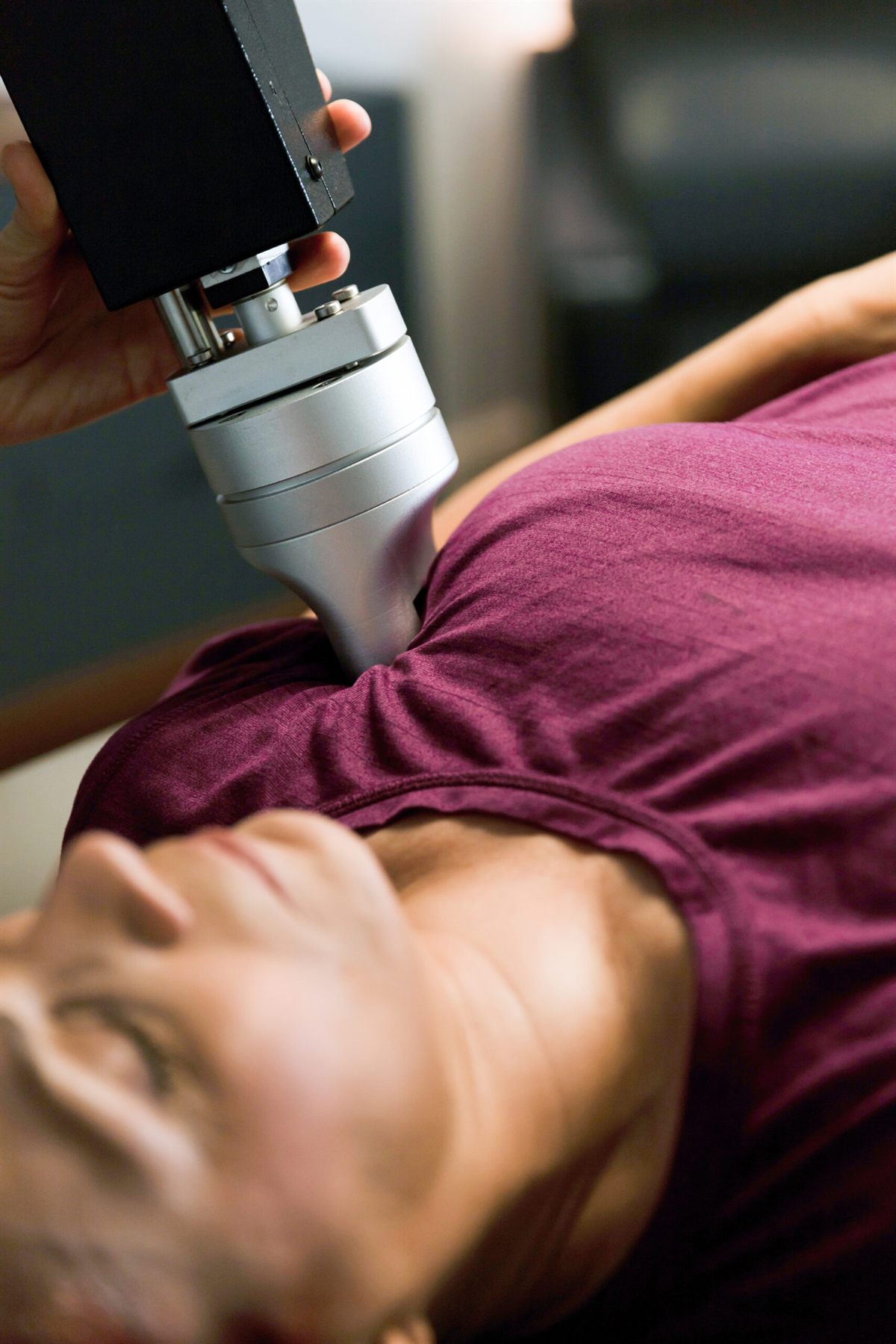 The RX2600 treatment head applying pressure to a patient's shoulder.