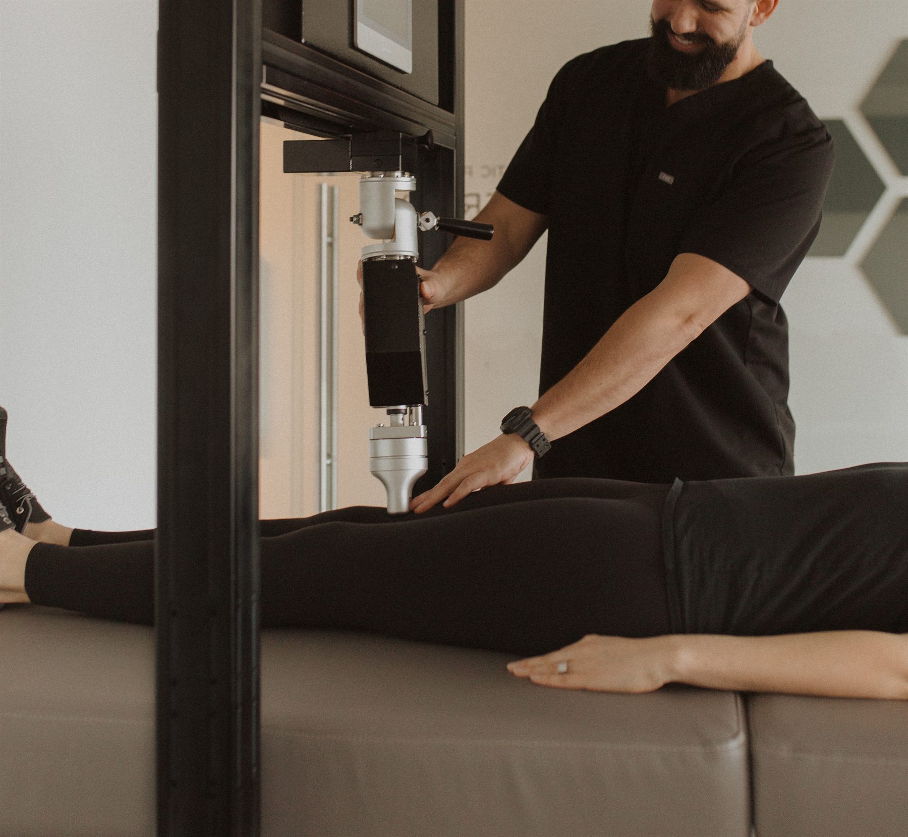 A clinician positioning the RX2600 arm over a patient's leg on the treatment bed.